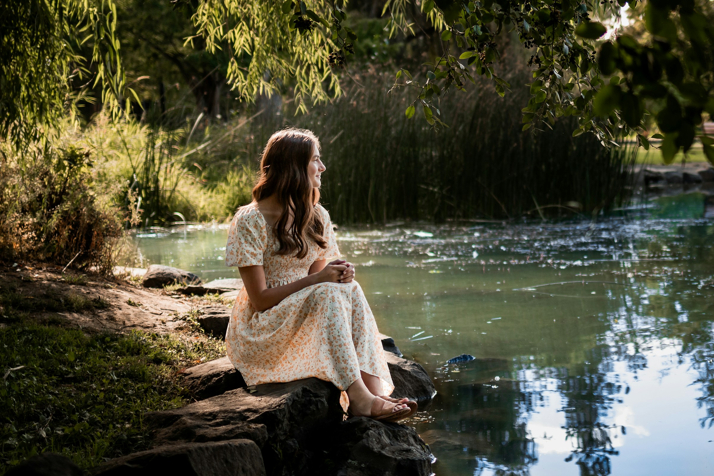 Young woman sitting by a lake