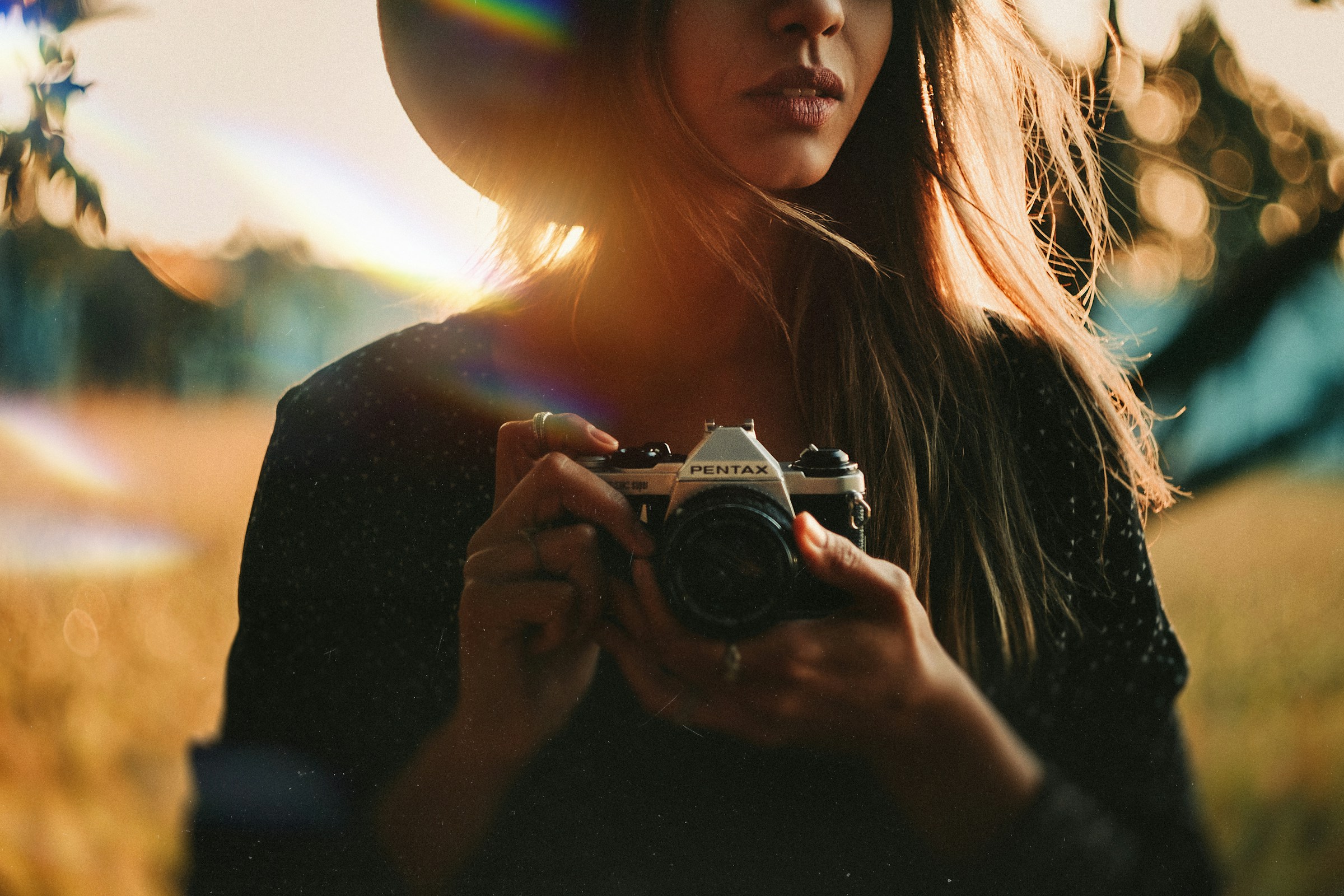 Woman holding a camera in warm backlit sunlight
